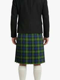Person wearing a black coat and green plaid kilt on a white background