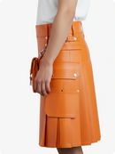 Orange leather skirt worn by a person on a white background