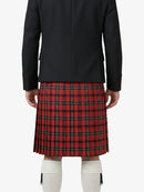 Person wearing a black coat and red plaid kilt on a white background