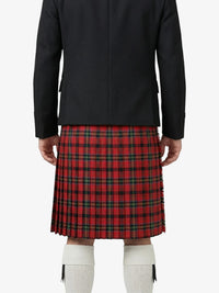 Person wearing a black coat and red plaid kilt on a white background