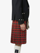 Person wearing a black jacket and red plaid kilt on a white background