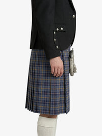 Person wearing a black jacket and plaid kilt on a white background