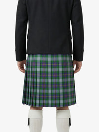 Person wearing a black jacket and green plaid kilt on a white background