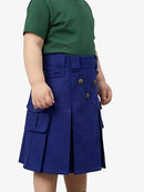 Person wearing a green shirt and blue skirt with buttons on a white background