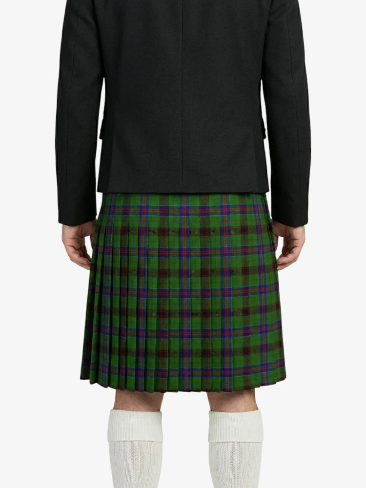 Person wearing a black jacket and green plaid kilt on a white background