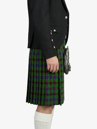 Person wearing a black jacket and green plaid kilt on a white background