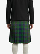 Person wearing a black blazer and green plaid kilt on a white background