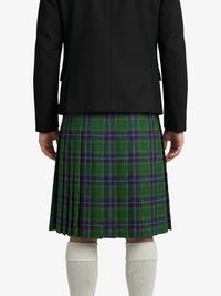 Person wearing a black blazer and green plaid kilt on a white background