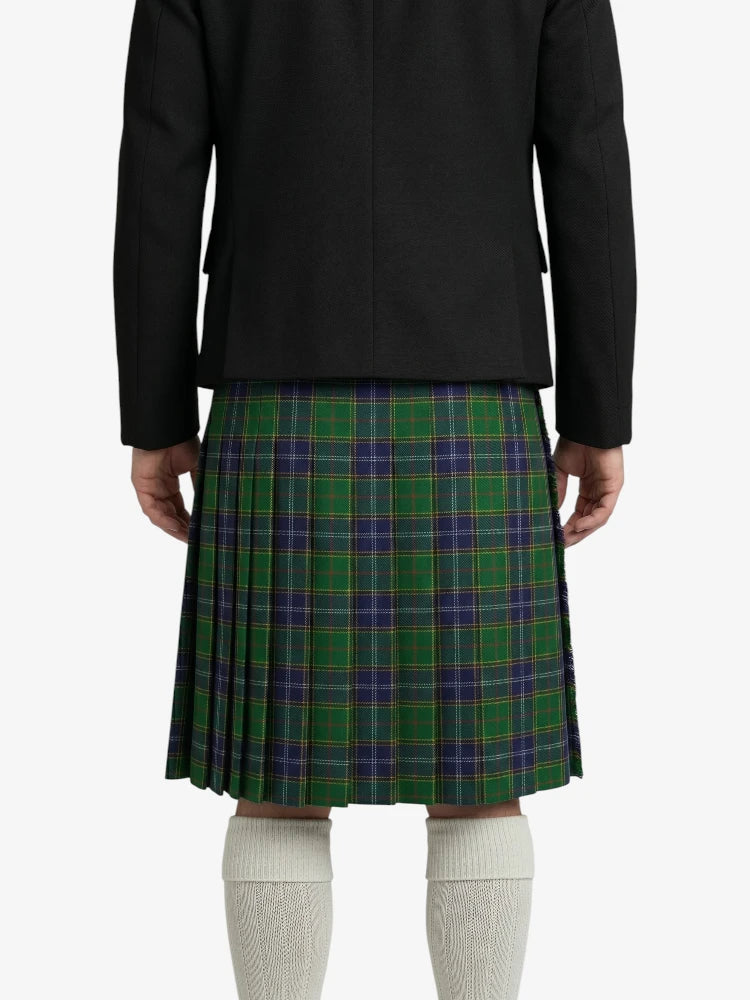 Person wearing a black blazer and green plaid kilt on a white background