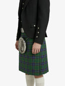 Person wearing a black jacket and green plaid kilt on a white background