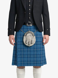 Person wearing a blue plaid kilt with a black jacket on a white background