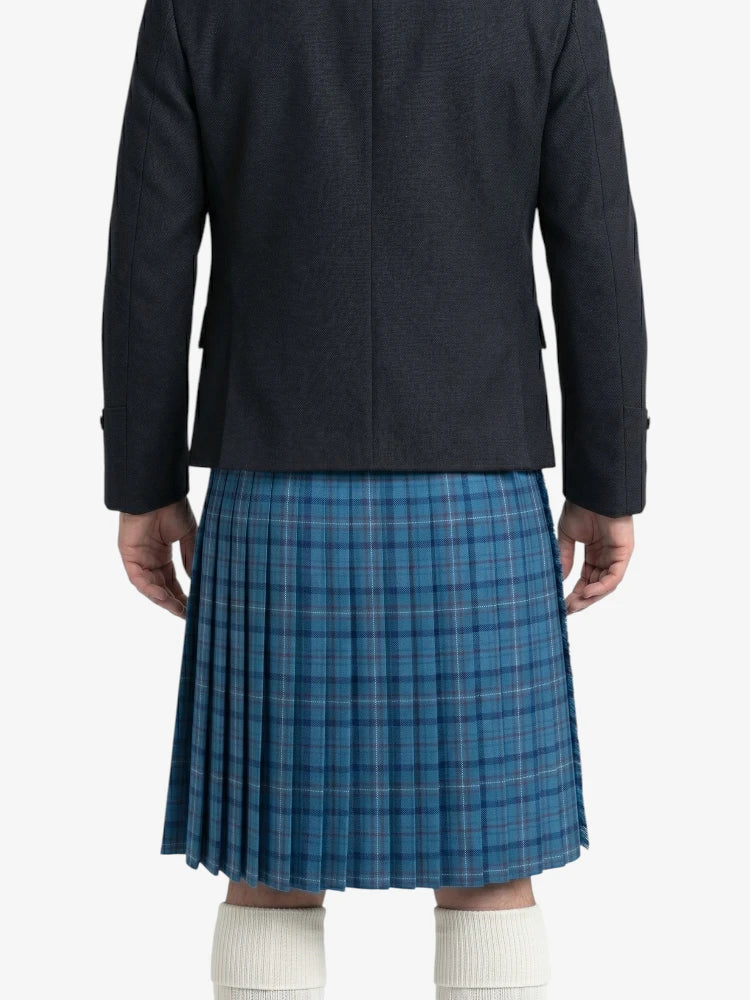 Person wearing a dark jacket and blue plaid kilt on a white background
