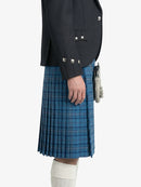 Person wearing a dark gray jacket and blue plaid kilt on a white background
