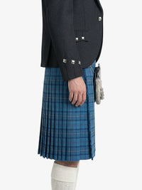 Person wearing a dark gray jacket and blue plaid kilt on a white background