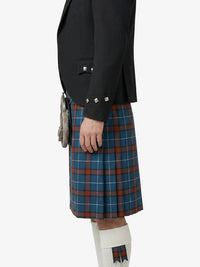Person wearing a black jacket and blue plaid kilt on a white background