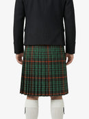 Person wearing a black jacket and green plaid kilt on a white background