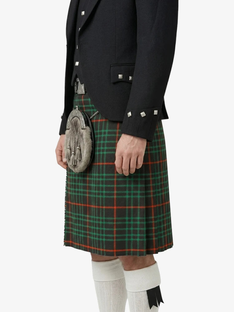 Person wearing a black jacket and green plaid kilt on a white background