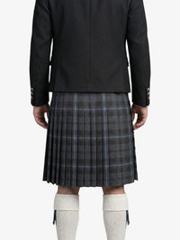 Person wearing a black jacket and plaid kilt on a white background