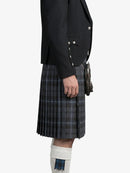 Person wearing a black jacket and plaid kilt on a white background