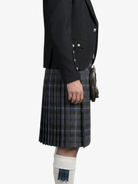 Person wearing a black jacket and plaid kilt on a white background
