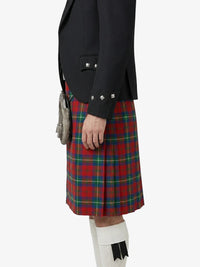 Person wearing a black jacket and red plaid kilt on a white background