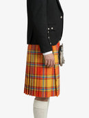 Person wearing a black jacket and a colorful plaid kilt on a white background
