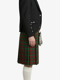 Person wearing a black blazer and green plaid kilt on a white background