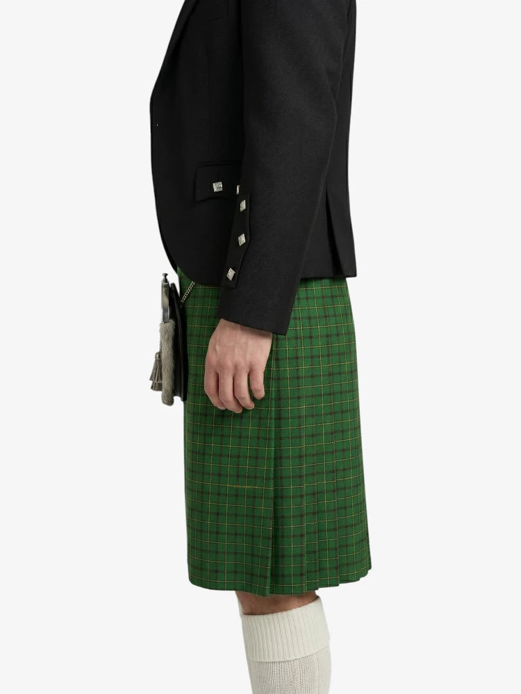 Person wearing a black jacket and green plaid kilt on a white background