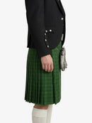 Person wearing a black jacket and green plaid kilt on a white background
