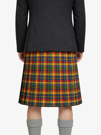 Person wearing a black coat and colorful plaid skirt on a white background
