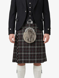 Person wearing a traditional Scottish kilt with a jacket on a white background