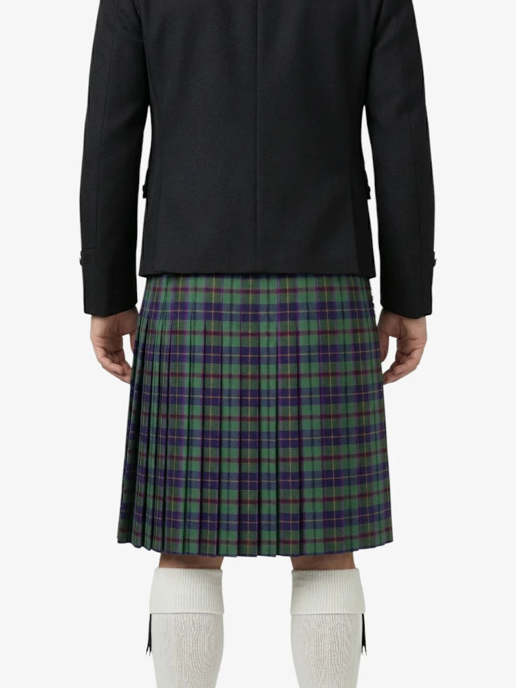Person wearing a black jacket and green plaid kilt on a white background