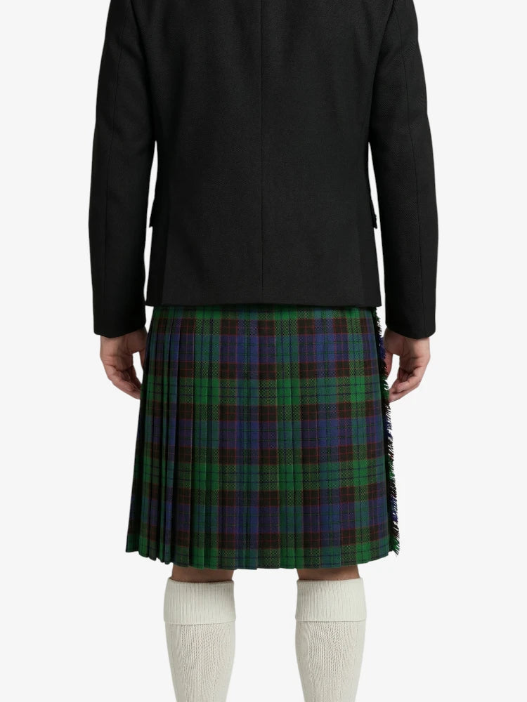 Person wearing a black jacket and green plaid kilt on a white background