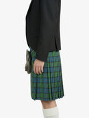 Person wearing a black jacket and green plaid kilt on a white background