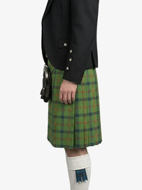 Person wearing a green plaid kilt with a black jacket on a white background