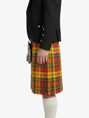 Person wearing a black jacket and a yellow plaid kilt on a white background