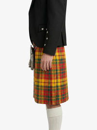 Person wearing a black jacket and a yellow plaid kilt on a white background