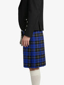 Person wearing a black jacket and blue plaid kilt on a white background
