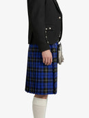 Person wearing a black blazer and blue plaid kilt on a white background