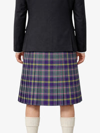 Person wearing a black jacket and plaid kilt on a white background