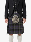 Person wearing a traditional Scottish kilt with a jacket and white socks on a white background