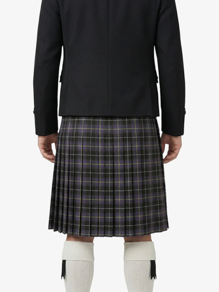 Person wearing a black blazer and plaid kilt on a white background