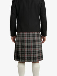 Person wearing a black coat and plaid kilt on a white background