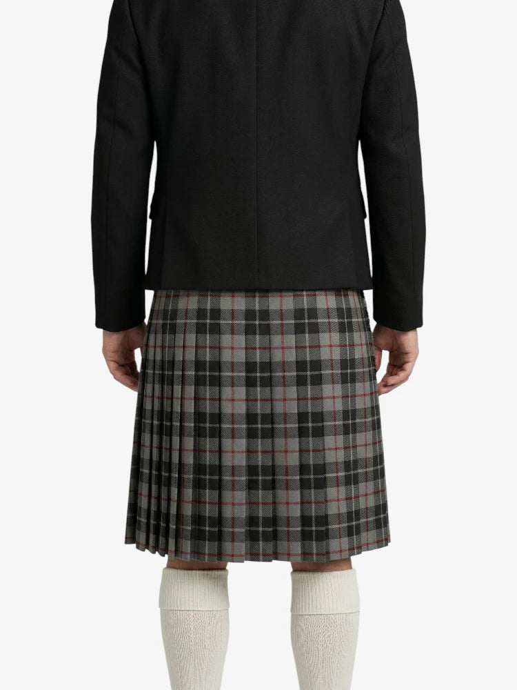 Person wearing a black coat and plaid kilt on a white background