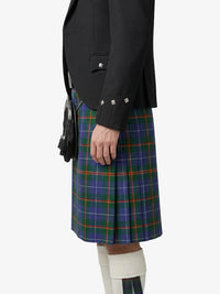 Person wearing a black jacket and plaid kilt on a white background