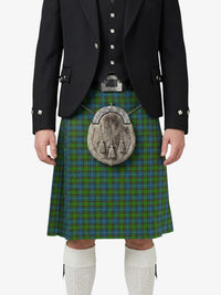 Person wearing a traditional Scottish kilt with a tartan pattern on a white background