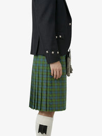 Person wearing a dark jacket and green plaid kilt on a white background