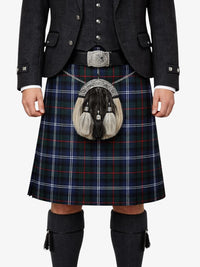 Person wearing a traditional Scottish kilt with a tartan pattern on a white background