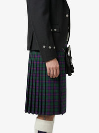 Person wearing a dark jacket and plaid kilt on a white background