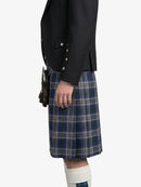Person wearing a black blazer and blue plaid kilt on a white background